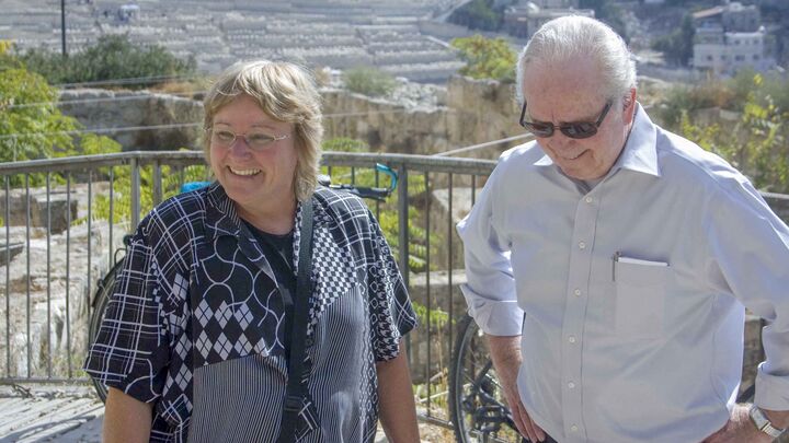 Gerald Flurry with a guide at a railing above an excavation, the city behind them