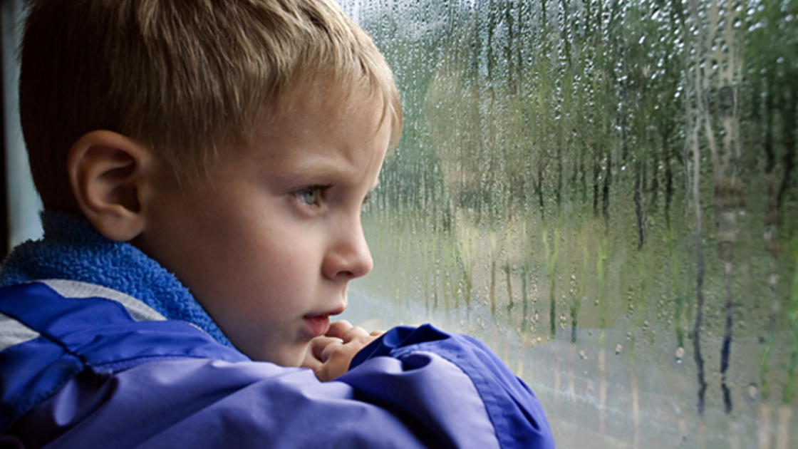 SAD BOY LOOKS IN WINDOW