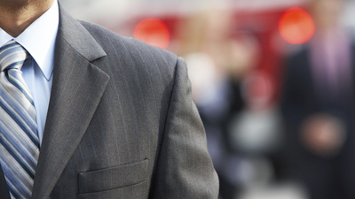 Close Up Of Businessman Walking Along City Street