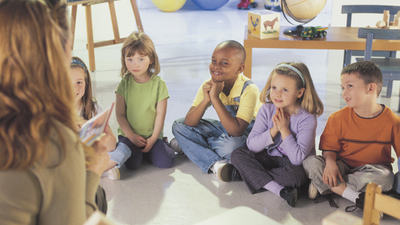 Woman speaking to children in classroom