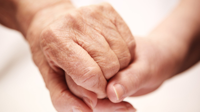 adult helping senior in hospital