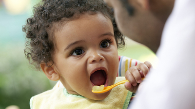 Father Watching Baby Boy Eating