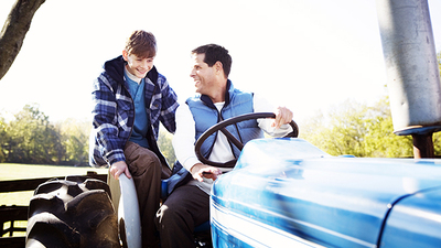 Father and son driving tractor