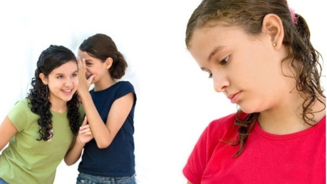 two young girls laughing behind another girls back