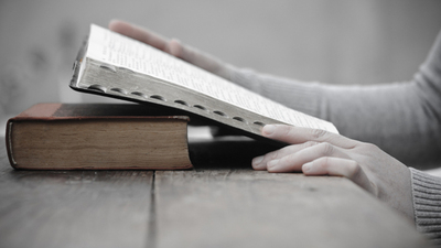 A photo woman studying the Bible, looking for what God says about predestination.