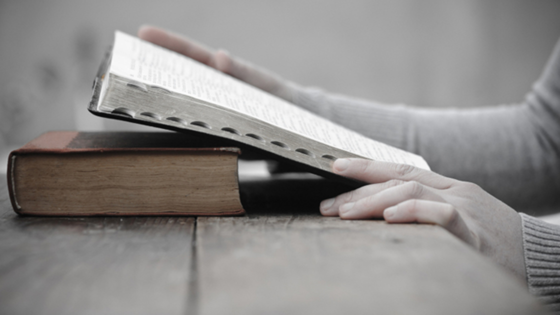 A photo woman studying the Bible, looking for what God says about predestination.