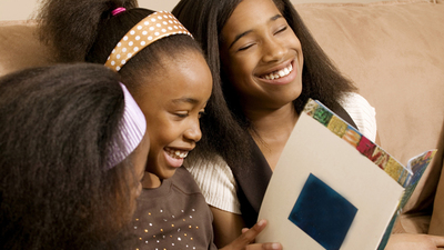 Girls reading and laughing together