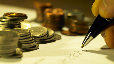 coins and a hand making a signature