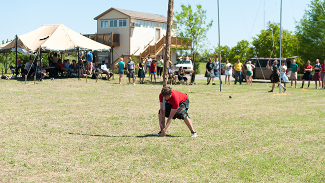 Brandon Nice lifts a caber while Daniel Westerbaan tosses a sheaf at the Gary Rethford Highland Games held on the campus of Herbert W. Armstrong College (Photo: Matt Friesen). 