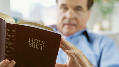 low angle view of a senior man reading the bible