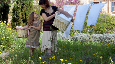 Mother and daughter (8-9) with baskets in domestic garden.