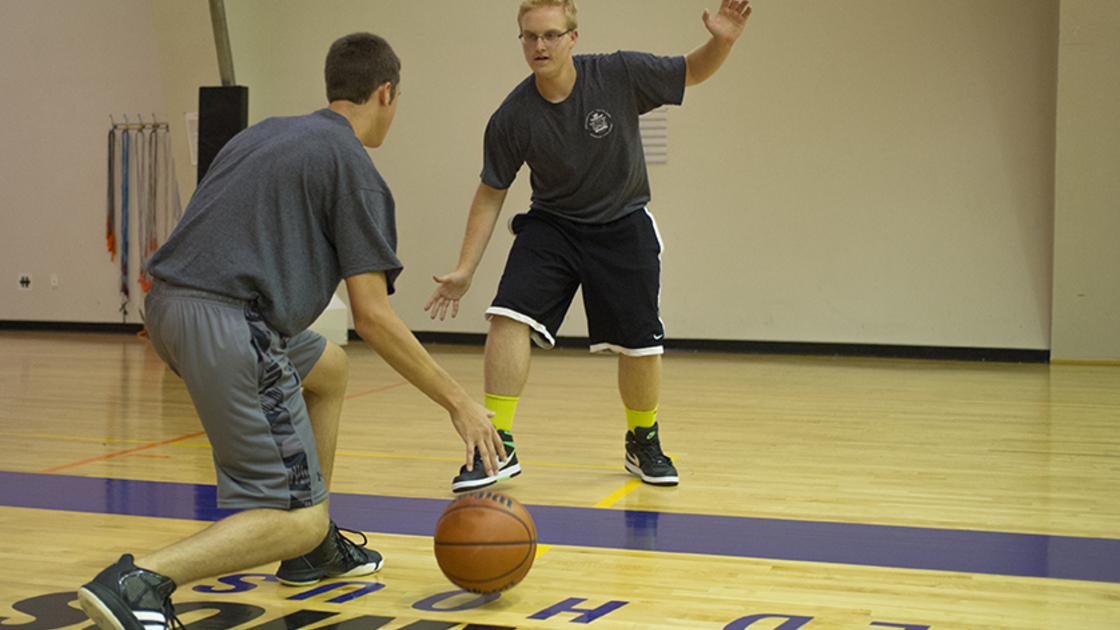 Austin Ceglenski dribbles the ball while Austin Williams guards him in a defensive stance drill. 