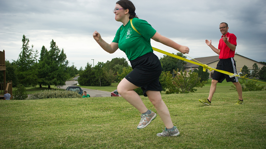 Instructor Steve Hercus cheers on Jeanine as she pulls a tire to help her learn proper sprint posture. 