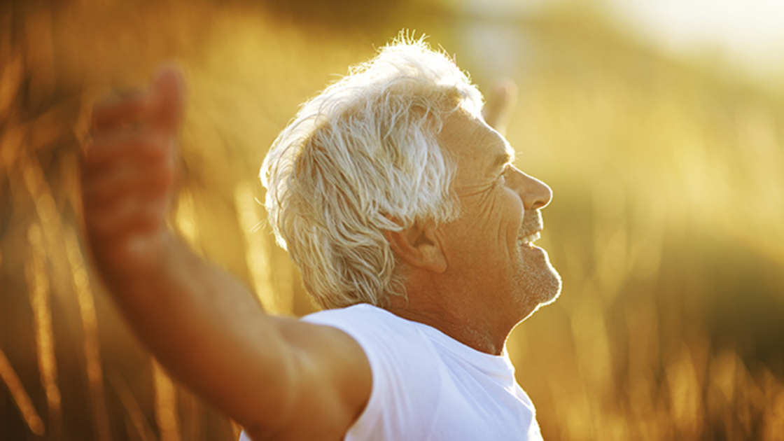 A happy man outside enjoying the fresh air and sunshine.