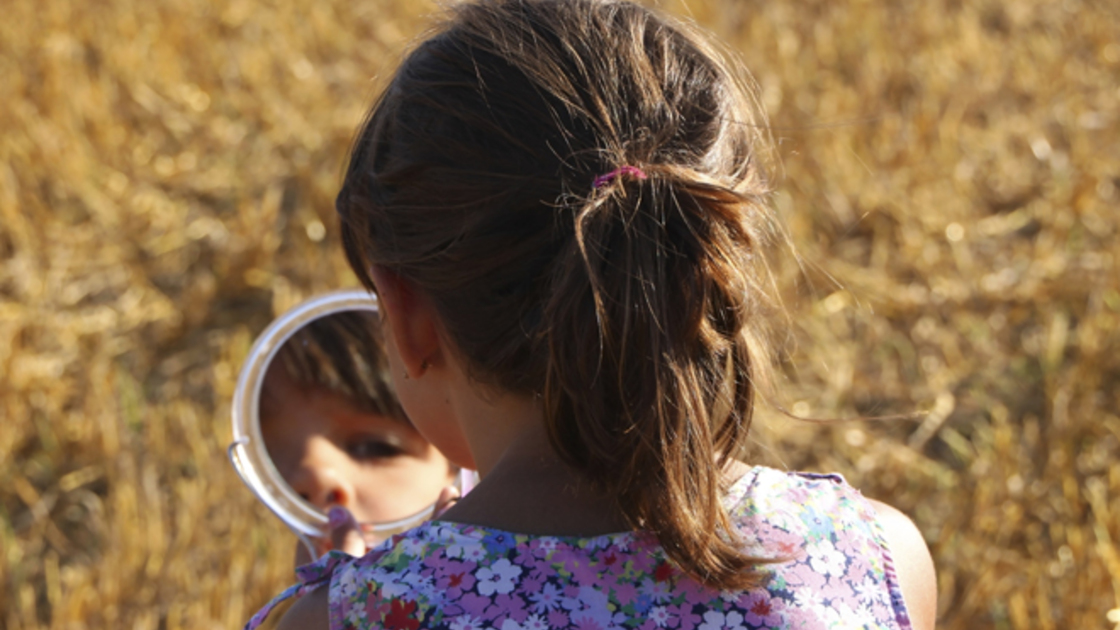 Little girl looking in the mirror