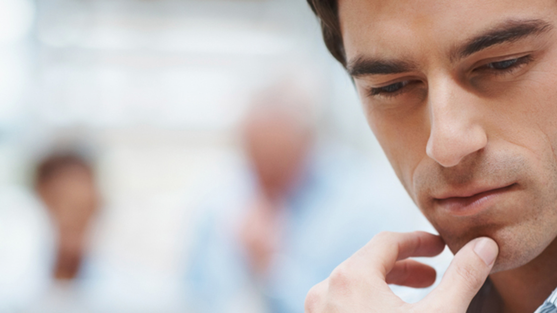 16x5(Why Pray)
Closeup of a thoughtful smart business executive with colleagues in the background