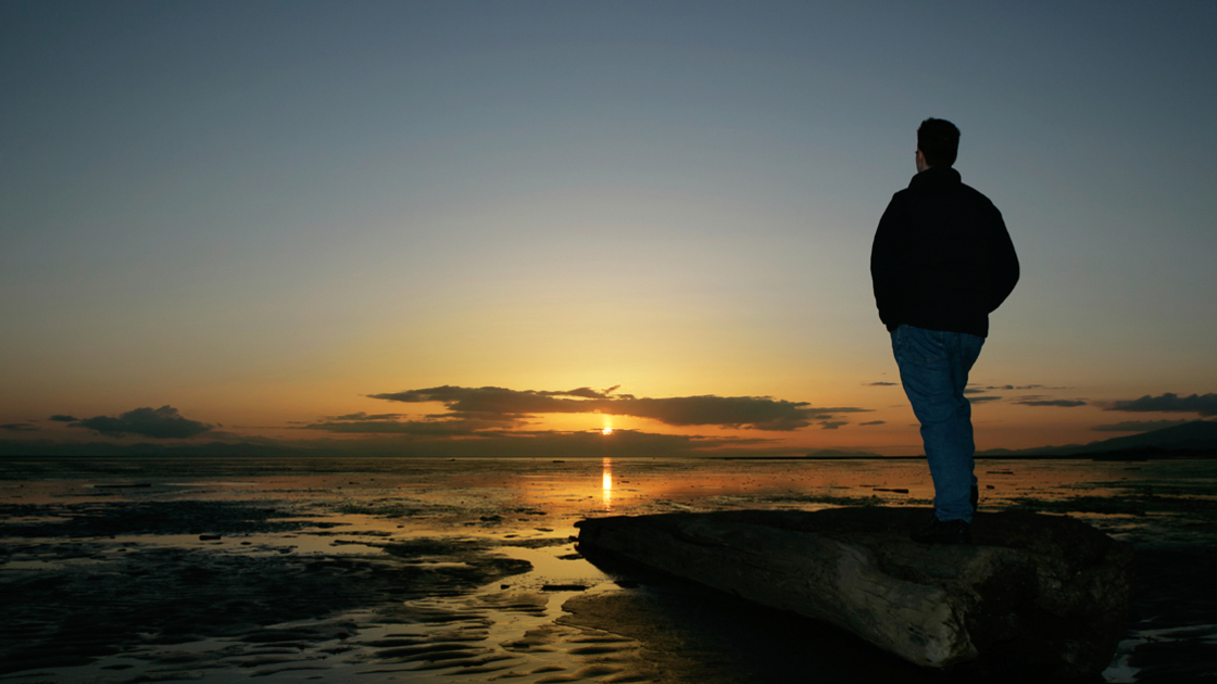 lonely man on beach in silhouette at sunset (XL)