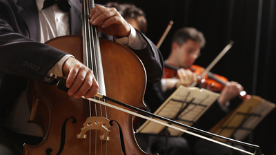 Symphony concert, a man playing the cello, hand close up