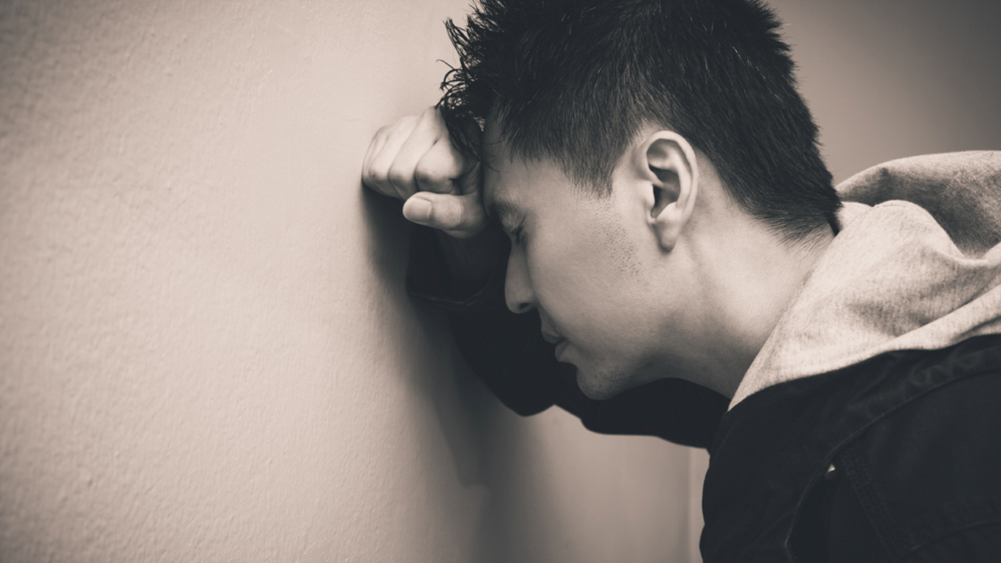 16x9(Dictator in your mind)
Depressed asian man with fist clenched leaning his head against a wall