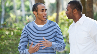 16x9(Resolving offenses)
African American father (40s) and son (19 years, mixed race African American and Caucasian) walking and talking in park.