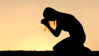 16x9(Prayers of repentance)
A silhouette of a young Christian woman is bowing her head in prayer, and desperation outside during sunset.