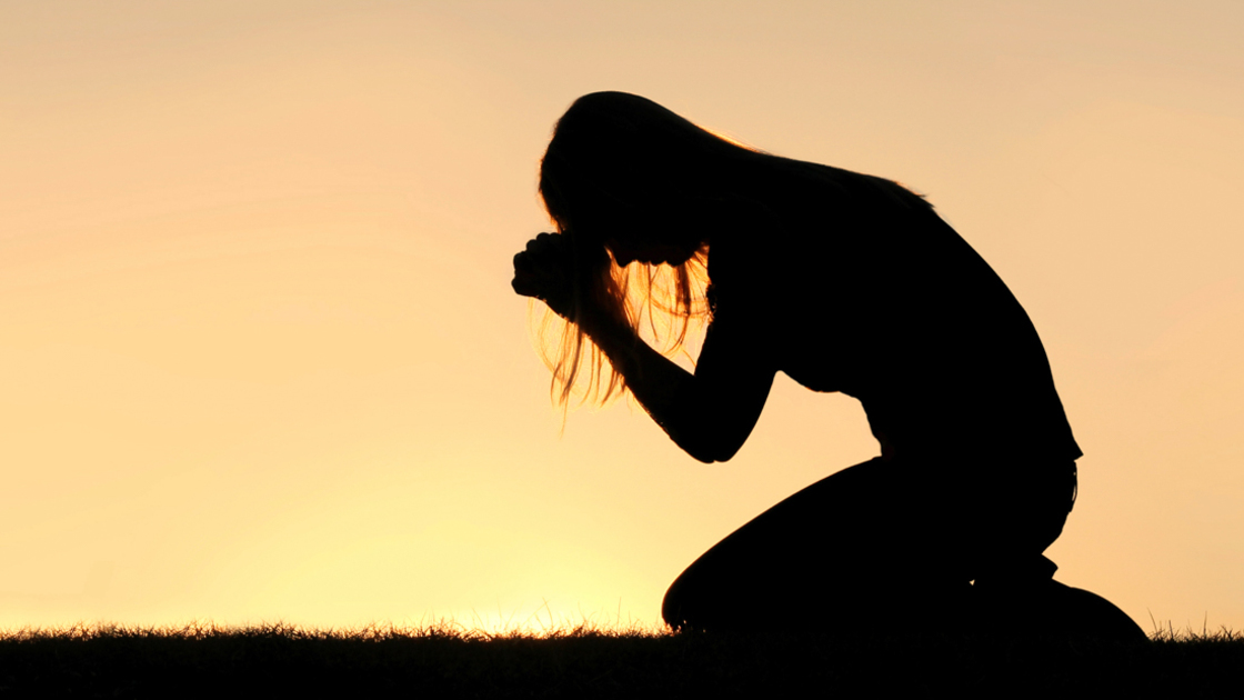 16x9(Prayers of repentance)
A silhouette of a young Christian woman is bowing her head in prayer, and desperation outside during sunset.