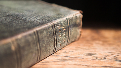 16x9(The Bible: A Coded Book)
Leather covered old bible lying on a wooden table in a beam of sunlight (not an isolated image) VERY SHALLOW Depth of field – Focus on Text “Holy Bible”