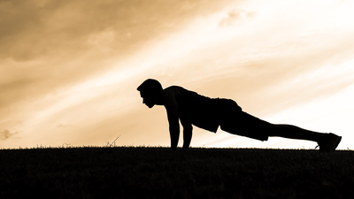 Man doing push ups in the park.