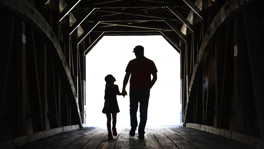 Father And Daughter On A Covered Bridge