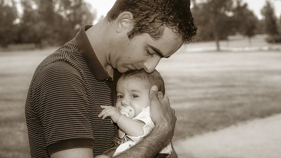 Father holding his daughter close in his arms.