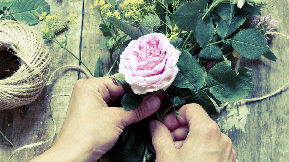 Florist at work. Woman making summer floral decorations