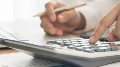 Businessman using a calculator to calculate the numbers