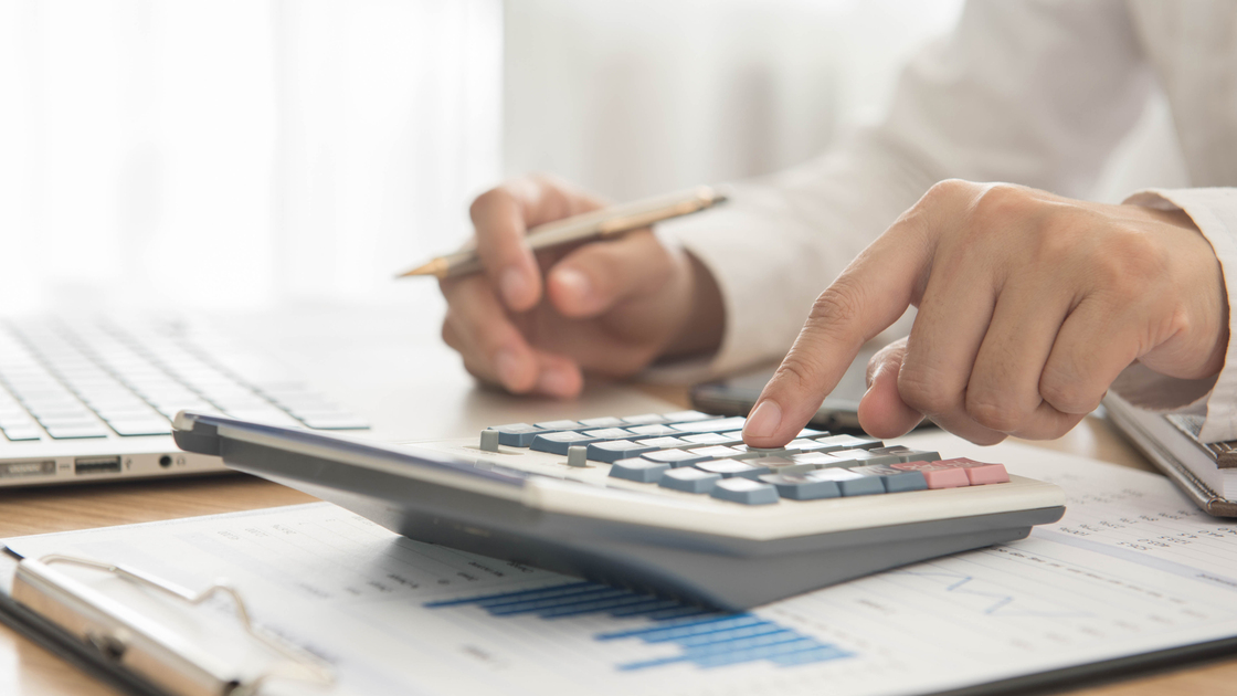 Businessman using a calculator to calculate the numbers