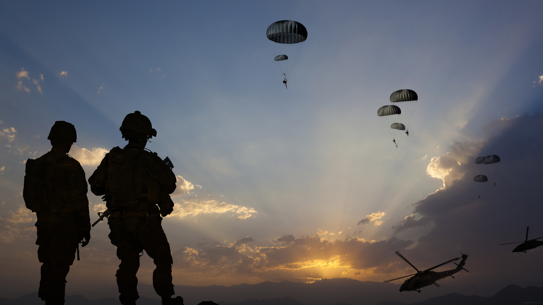 ATTENTION FOR INSPECTOR: This is a composite photo and the date of model releases are different from the date of image. Please consider this. Paratroopers jumping from the plane and military helicopters leave behind soldiers for a night mission.