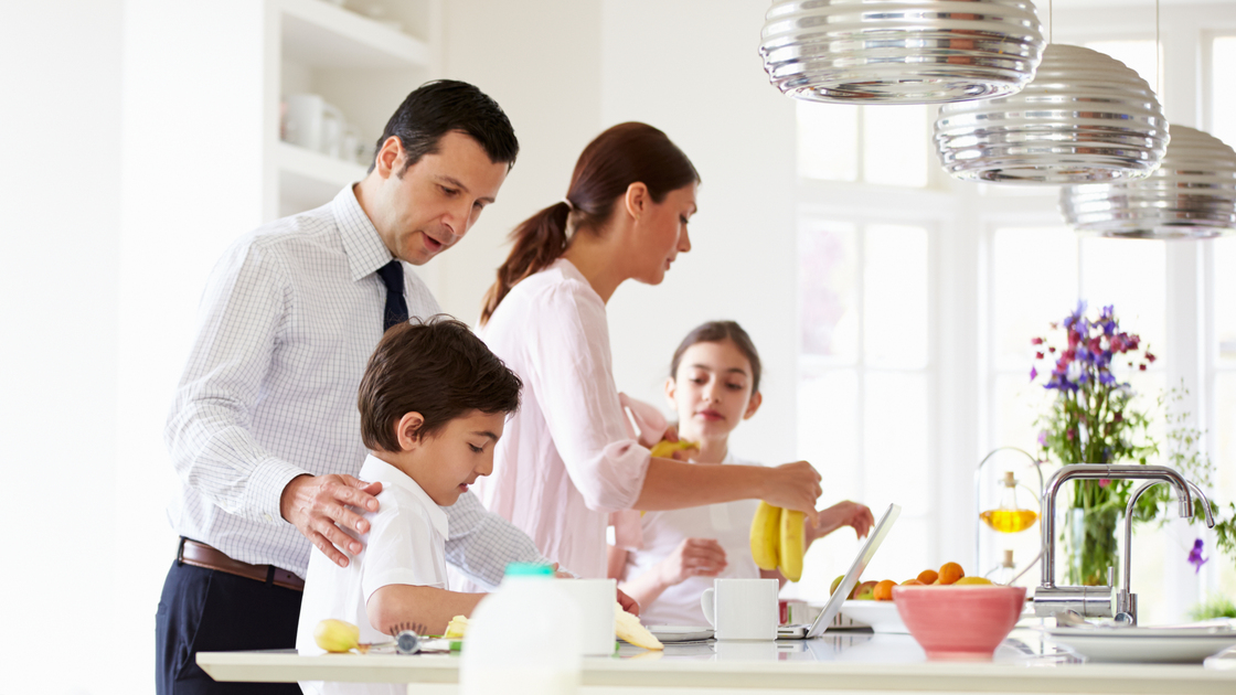 Family Helping To Clear Up After Breakfast Before School And Work