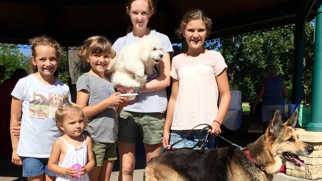 Pictured (L to R): Katelyn Aldrich, Violet Kaleho, Chloe Kaleho, Erica Anderson (holding Ozzie the Dog in her arms), Sofia Kaleho (holding Kaia the dog on a leash).