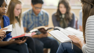 Diverse group of teens studying the Bible.