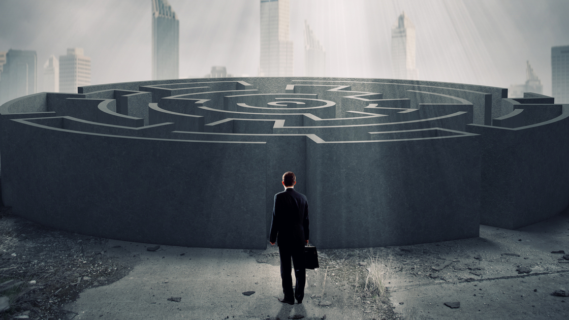 Successful businessman standing near the entrance of labyrinth