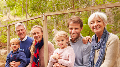 Multi-generation family portrait on a bridge in a forest