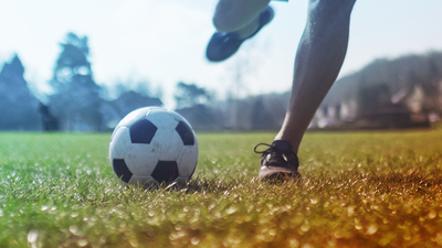 Unseen man about to kick a football