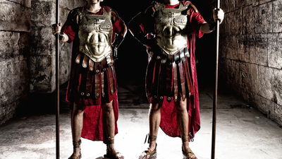 Two Roman soldiers holding spears in vestibule.