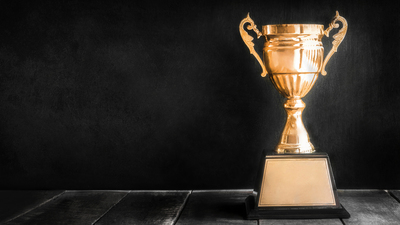 champion golden trophy on wood table with blackboard copy space