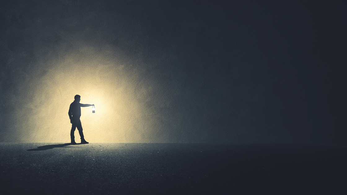 Man with lamp walking illuminating his path