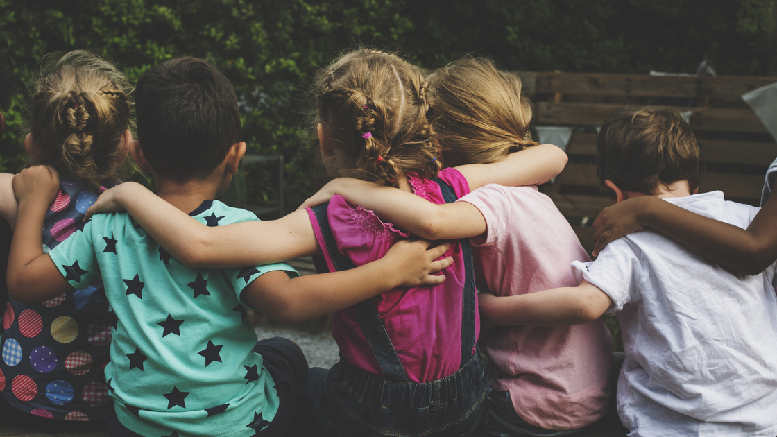 Group of kindergarten kids friends arm around sitting together