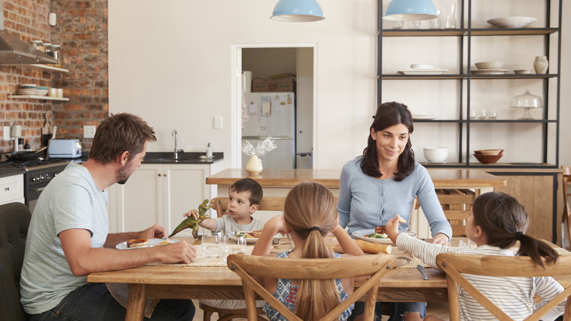 Family Eating Meal In Open Plan Kitchen Together