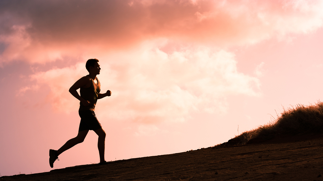 Fitness male running outdoors during sunset. Healthy lifestyle concept. 