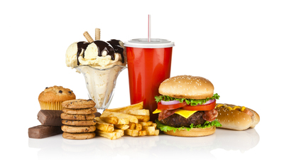 Group of unhealthy food isolated on white background. The composition includes, candy bar, muffin, cookies, ice cream, french fries, a glass of soda, hamburger and a hot dog. This is an unhealthy food rich in carbohydrates, sugar and calories.  DSRL studio photo taken with Canon EOS 5D Mk II and Canon EF 70-200mm f/2.8L IS II USM Telephoto Zoom Lens