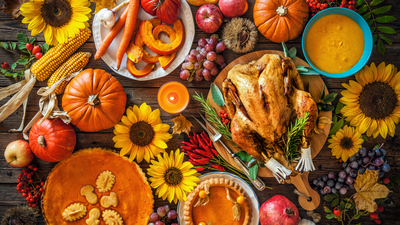 Thanksgiving dinner. Roasted turkey with pumpkins and sunflowers on wooden table