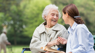 Senior woman with caregiver in the park