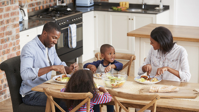 Family Eating Meal In Open Plan Kitchen Together